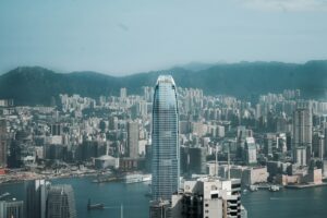 Modern skyscrapers rise above a busy city harbor